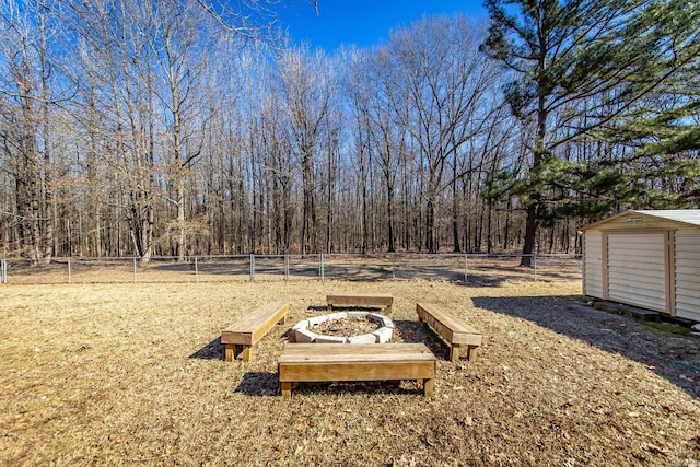 view of yard with a shed and a fire pit