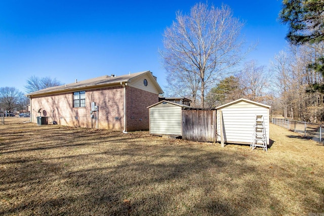 back of house featuring a yard and a storage shed