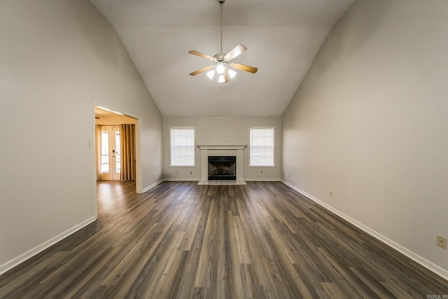 unfurnished living room with ceiling fan, dark hardwood / wood-style floors, high vaulted ceiling, and a tile fireplace