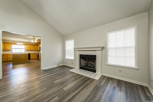 unfurnished living room featuring high vaulted ceiling, dark hardwood / wood-style flooring, sink, and a notable chandelier