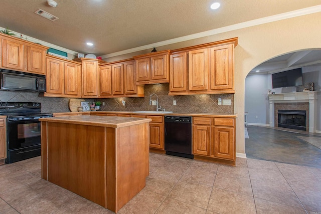 kitchen featuring sink, crown molding, a kitchen island, black appliances, and light tile patterned flooring