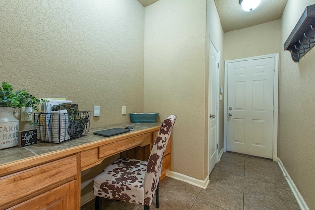 office with tile patterned flooring and built in desk