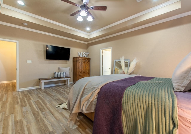 bedroom with a raised ceiling, crown molding, ceiling fan, and light hardwood / wood-style flooring