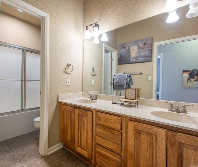 full bathroom with vanity, tile patterned floors, shower / bath combination with glass door, and toilet