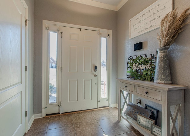 tiled entrance foyer featuring ornamental molding and a wealth of natural light