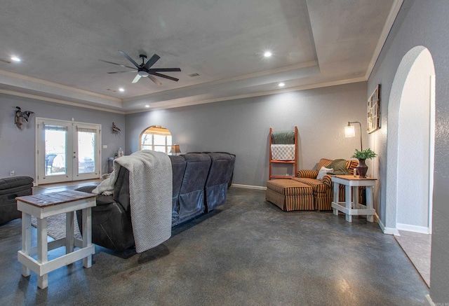 living room with crown molding, ceiling fan, and a tray ceiling