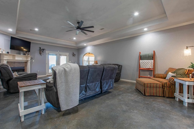 living room featuring crown molding, ceiling fan, and a tray ceiling