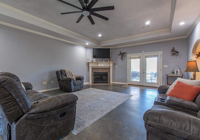 living room featuring french doors, ceiling fan, ornamental molding, and a tray ceiling