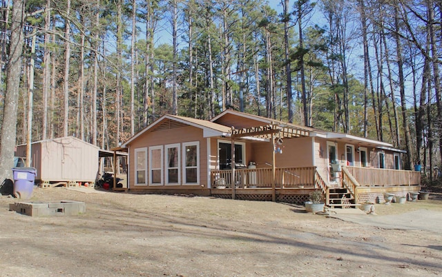 view of front of property featuring a deck and a storage unit