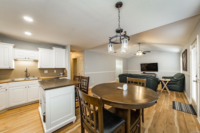 dining space with lofted ceiling, sink, light hardwood / wood-style flooring, and ceiling fan