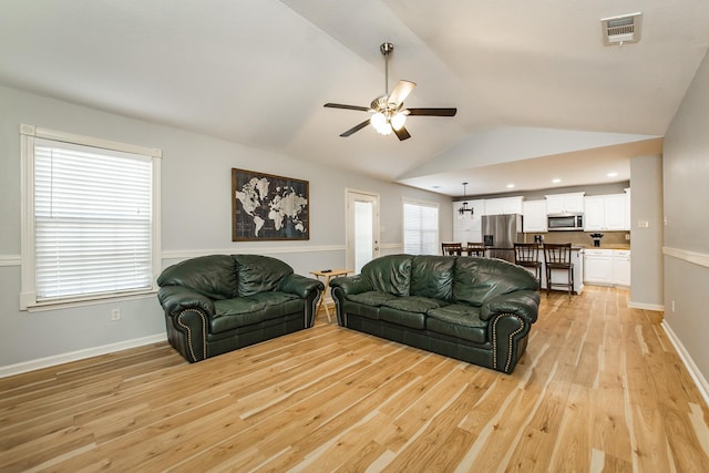 living room featuring lofted ceiling, light hardwood / wood-style floors, and ceiling fan