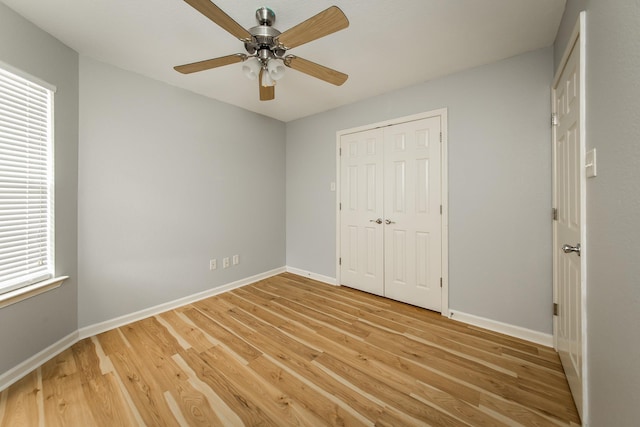 unfurnished bedroom featuring light hardwood / wood-style flooring, ceiling fan, and a closet