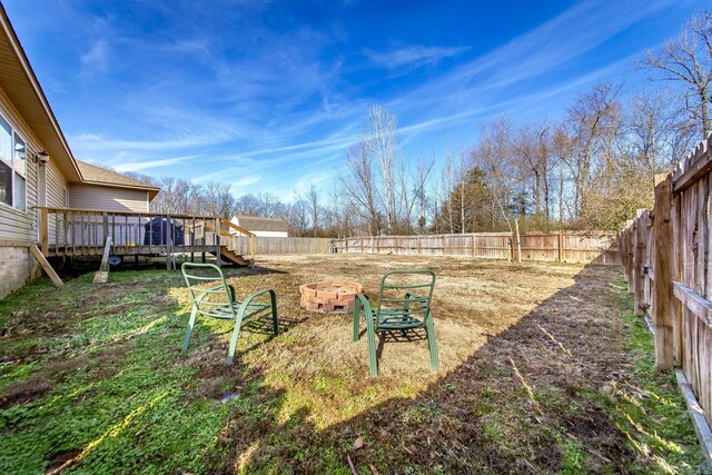 view of yard with a wooden deck and an outdoor fire pit