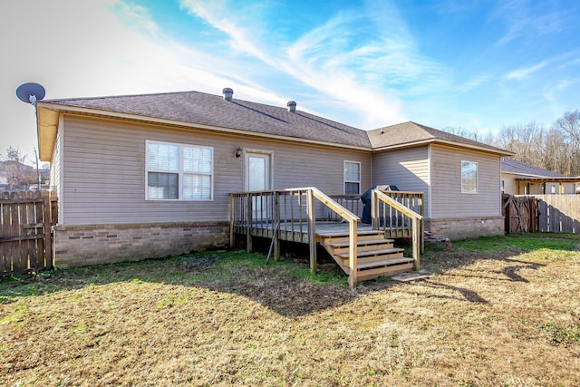 rear view of property with a wooden deck and a lawn