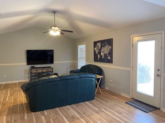 living room with a wealth of natural light, vaulted ceiling, and wood-type flooring