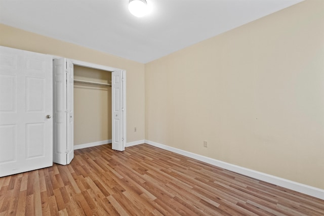 unfurnished bedroom with light hardwood / wood-style floors and a closet