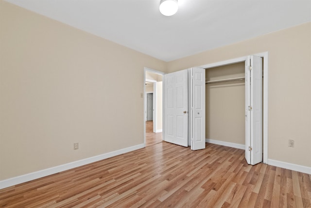 unfurnished bedroom featuring a closet and light wood-type flooring