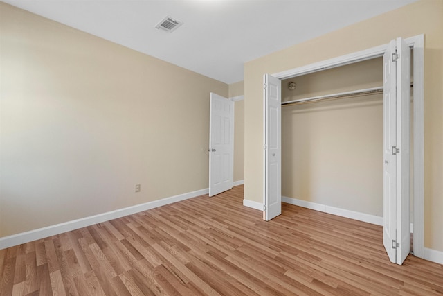 unfurnished bedroom featuring light hardwood / wood-style floors and a closet