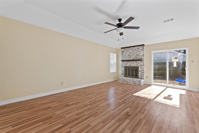 unfurnished living room featuring ceiling fan, a fireplace, and light wood-type flooring