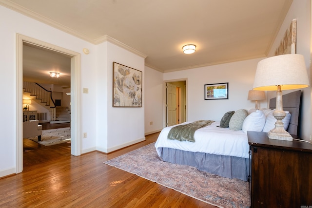 bedroom with hardwood / wood-style flooring and ornamental molding