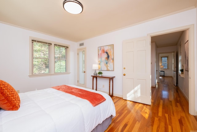 bedroom with crown molding and wood-type flooring