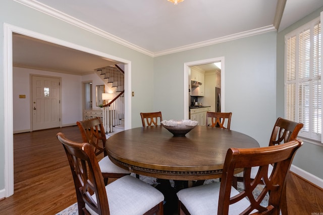 dining room featuring dark wood-type flooring and ornamental molding