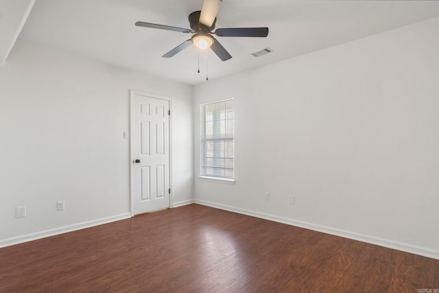 spare room with dark wood-type flooring and ceiling fan