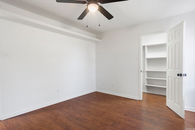 empty room featuring dark wood-type flooring and ceiling fan