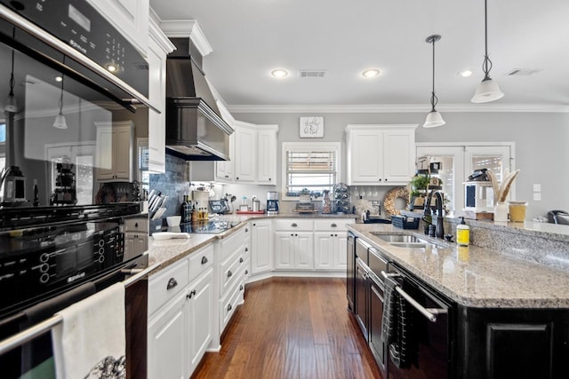 kitchen featuring white cabinetry, black electric stovetop, sink, and pendant lighting