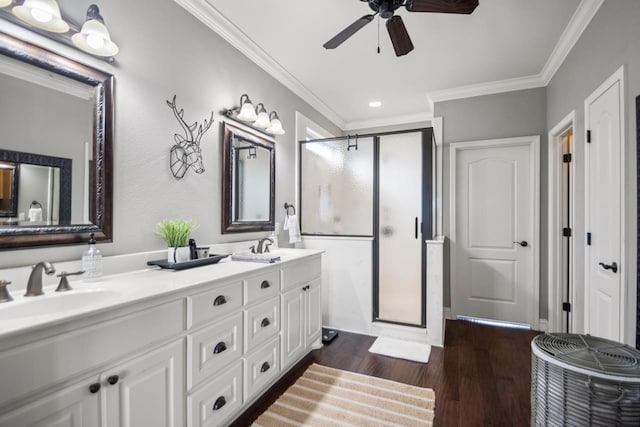 bathroom featuring a shower with door, ceiling fan, vanity, wood-type flooring, and ornamental molding