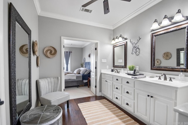 bathroom with crown molding, ceiling fan, vanity, and hardwood / wood-style floors