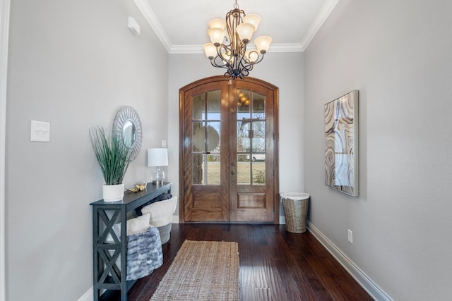 entryway with french doors, dark hardwood / wood-style floors, crown molding, and an inviting chandelier