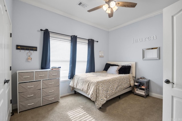 carpeted bedroom with ceiling fan and ornamental molding