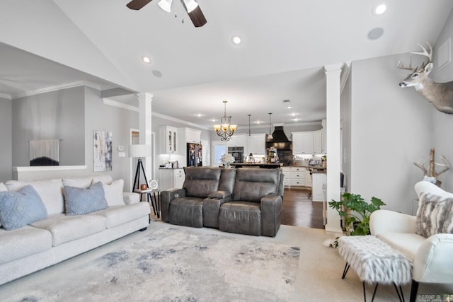 living room featuring ornate columns, vaulted ceiling, ceiling fan with notable chandelier, and crown molding