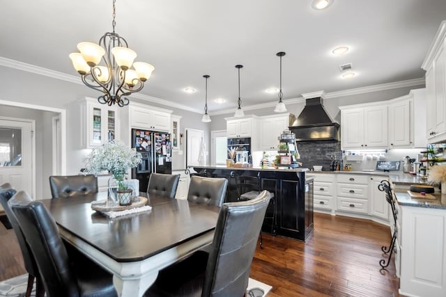 dining room with crown molding, dark hardwood / wood-style floors, and a chandelier