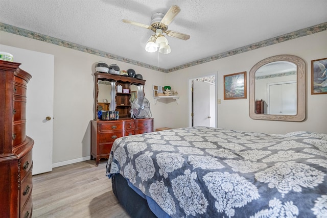 bedroom featuring ceiling fan, a textured ceiling, and light wood-type flooring