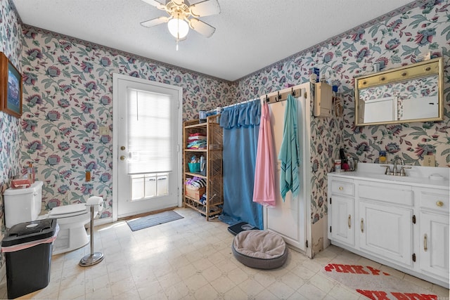 bathroom featuring vanity, curtained shower, a textured ceiling, and toilet