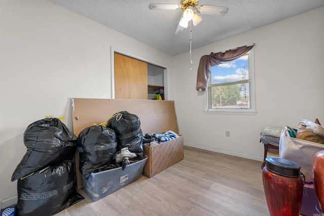 misc room with light hardwood / wood-style flooring and a textured ceiling