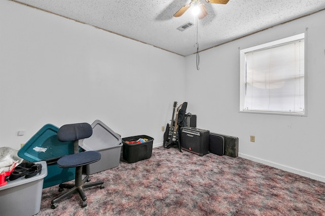 interior space featuring ceiling fan, a textured ceiling, and carpet