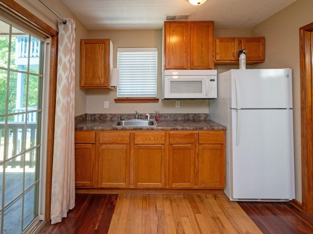 kitchen featuring sink, white appliances, and light hardwood / wood-style flooring