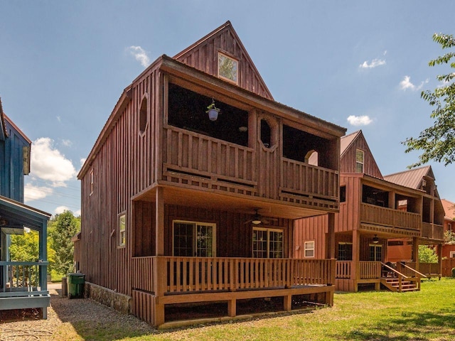 rear view of house with a lawn and a balcony