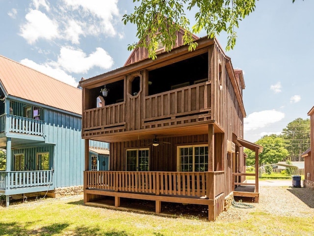 back of property featuring ceiling fan and a balcony