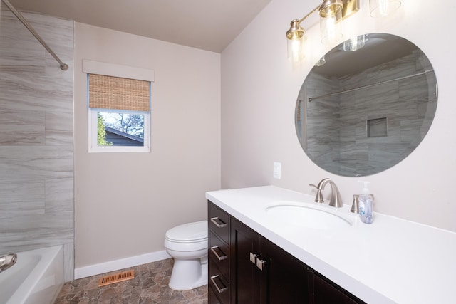 full bathroom with vanity, tiled shower / bath combo, and toilet