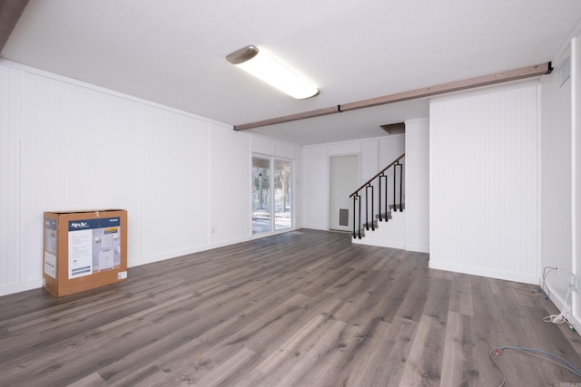 unfurnished living room with dark hardwood / wood-style floors and a textured ceiling