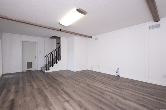 basement featuring dark hardwood / wood-style flooring and a textured ceiling