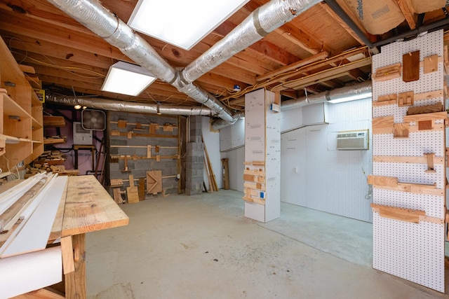 basement featuring a wall mounted air conditioner and a workshop area