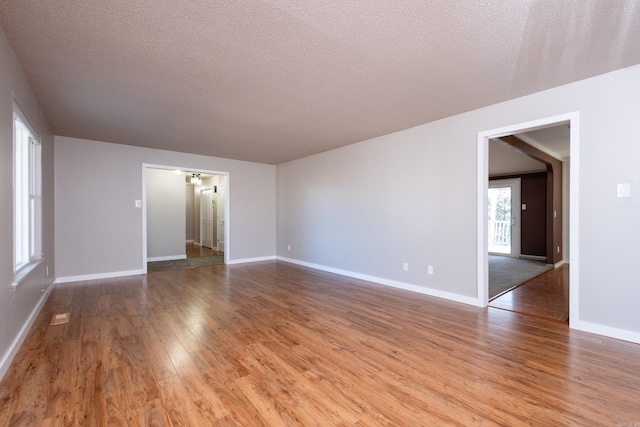 empty room with wood-type flooring and a textured ceiling