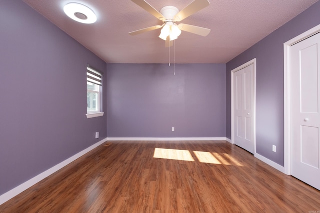 unfurnished bedroom featuring ceiling fan, dark hardwood / wood-style flooring, and a textured ceiling