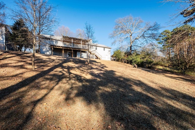 back of property with a wooden deck and a lawn