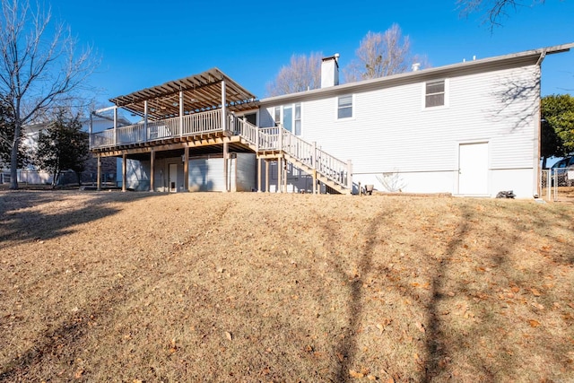 back of property with a wooden deck and a lawn